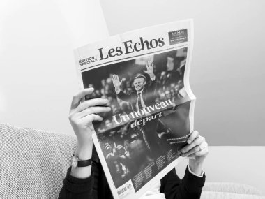 Rahat bir koltukta okuyan son Les Echos gazetesi beş yıllık ikinci dönem için Marine Le Pen 'i yendikten sonra görevdeki başkan Emmanuel Macron' la kapak oldu.