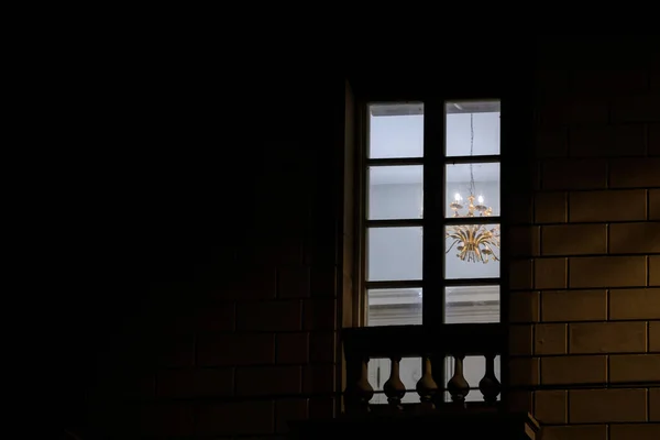 Cena noturna vista de rua de baixo da janela vazia com iluminação grande lustre — Fotografia de Stock