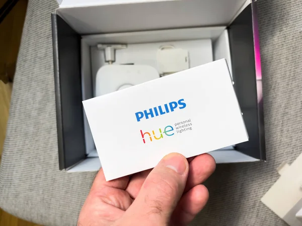 POV male hand holding Philips hue instruction manual after unboxing - a line of color changing LED lamps and white bulbs which can be controlled wirelessly — 스톡 사진