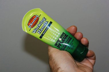 POV erkek eli yeni OKeeffe 'leri tutuyor. Çalışan eller son derece kuru ve çatlak elleri tamir ediyor.