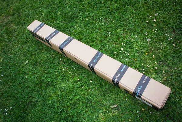 View from above of large and long Amazon Prime parcel cardboard with long good inside - delivered as a security measure in the backyard garden — Fotografia de Stock