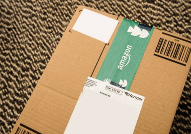 Paris, Fransa - 28 Ekim 2021: Hermes taşımacılık şirketinin logosuyla birlikte Amazon Prime karton paketinin halı zemininde yukarıdan yakın çekim