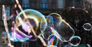 Sabundan yapılmış çoklu balon baloncuğu - arka planda apartman binası ile şehrin üzerinde uçuyor - emlak balonu konsepti