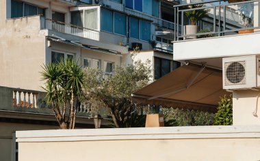 Balkonun çatısındaki klima, sıcak Akdeniz şehrindeki çok katlı binaların bakış açısına sahip. Sıcak hava dalgalarından korunuyor.