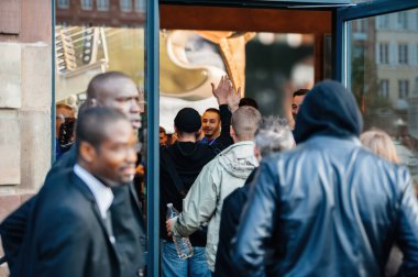 STRASBOURG, FRANCE - SEP, 19 2014: Employees give high-fives to customers as they enter the Apple Store Computers to purchase the latest iPhone Pro Se smartphone