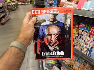 Frankfurt, Germany - Aug 6, 2022: POV male hand holding latest German Der Spiegel magazine with Vladimir Putin on cover and headline He is the people
