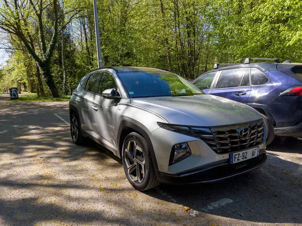 Paris, France - Apr 17, 2022: Front view of new Hyundai Tucson silver SUV parked in city - futuristic headlight of the car