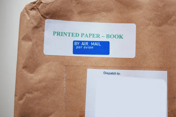 Printed paper book by air mail par avion sticker on the cardboard box paper of a internet ordered parcel