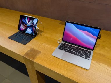 Paris, France - Ap 7, 2022: New iPad Pro and latest MacBook Pro laptop computer on the wooden table of Apple Computers Store