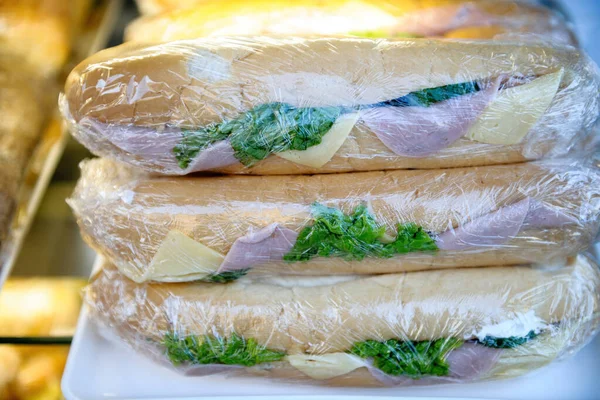 Delicious Sandwiches White Bread Ham Cheese Lettuce Salad Wrapped Plastic — Zdjęcie stockowe