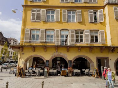 Strasbourg, France - Apr 10, 2022: Visiting Strasbourg eating drinking at the Cafe Montmartre in the central part of the city - drinking coffee eating croissants outdoor cafe