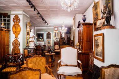 PAris, France - Sep 18, 2015: Antique store interior view from the street with no customers multiple artefacts, furniture and paintings - decoration of the house