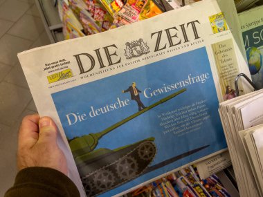 Berlin, Germany - Apr 23, 2022: The german question of moral issue headline depicting illustration of Olaf Scholz balancing on a tank main gun