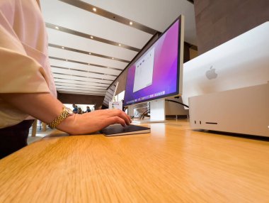 Paris, Fransa - 9 Sep 2022: Yeni güçlü Mac Stüdyo bilgisayar çalışma istasyonuna bakan kadın Apple 'ın sihirli iz sürme platformunu test ediyor - Apple Store alışveriş merkezi