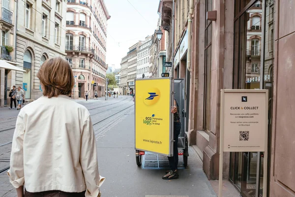 2022年9月9日フランス ストラスブール ネスプレッソに小包を配達する電動自転車運送で手紙小包を探している郵便労働者の後方ビュークリックして収集 — ストック写真