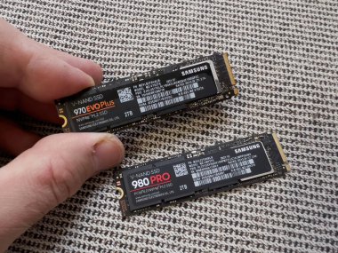 Paris, Fransa - 8 Nisan 2022: POV erkek eli Samsung 980 Pro NVME kişisel bilgisayar veya Mac Apple güncellemesi için sabit diski 970 Evo Plus ile karşılaştırıyor