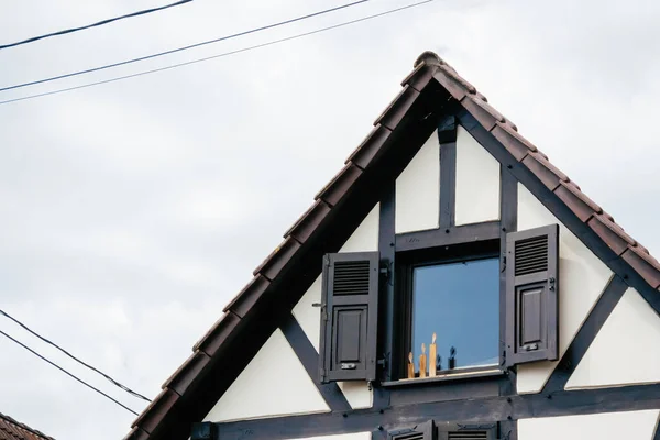 Candles made from wood at the window sill of a rustic village house