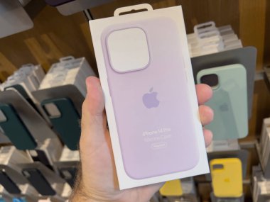 Paris, Fransa - 16 Sep 2022: Apple Store 'da yeni mor iPhone 14 Pro deri çantalı ve şarj olan POV erkek el ele tutuşma paketi
