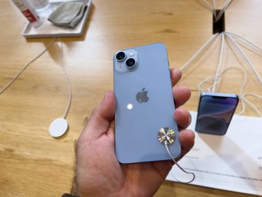 Paris, Fransa - 16 Eylül 2022: Yeni gökyüzü mavisi Apple Computers iPhone 14 'ü elinde tutan müşteri, fırlatma gününde çift güçlü kamera ve uydu görüntüleme ve kaza tespiti yapıyor.