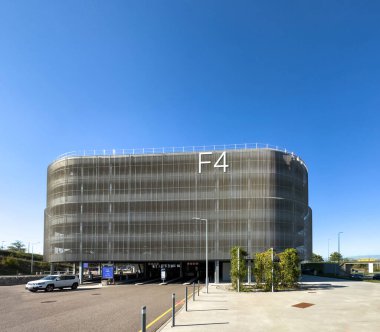 Basel, İsviçre - 22 Eylül 2022: EuroAirport 'taki F4 otoparkının modern binası - Basel Mulhouse Freiburg Havaalanı ön cephesinde büyük F4 tabelası ve Jeep arabasının geçişi