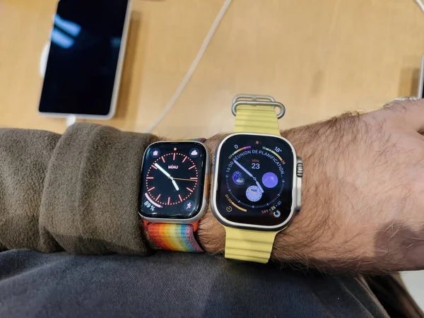 Paris, Fransa - 23 Eylül 2022: Apple Watch Ultra ve Apple Watch 7 ile erkek bileği, Apple Store 'da yeni titanyum Apple Watch Ultra gibi uç aktiviteler için tasarlanmış yeni titanyum Apple Watch Ultra satışının ilk gününde karşılaştırıldı