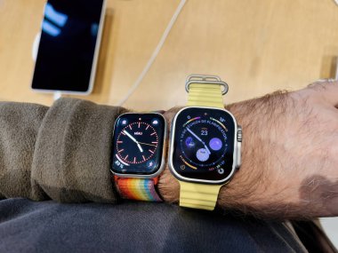 Paris, Fransa - 23 Eylül 2022: Adam aynı bilekte Apple Serisi 8 ile dayanıklılık sporları, seçkin sporcular, öncü sporcular gibi uç aktiviteler için tasarlanmış yeni titanyum Apple Watch Ultra 'yı karşılaştırıyor.