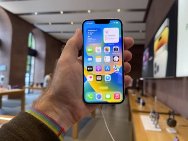 Paris, Fransa - Bölüm 16, 2022: POV erkek eli yeni mor renkli Apple Bilgisayarlı iPhone 14 tanıtım gününde çift güçlü kamera araba kazası algılama ve uydu SOS