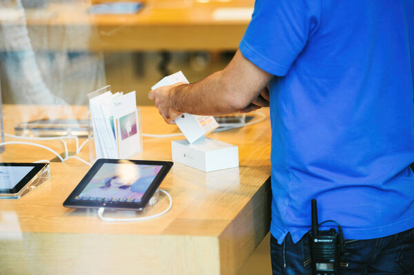 Страсбург, Франция - 19 сентября 2014 г.: Интерьер Apple Store отражает с гением работника сканирования коробки кода нового смартфона iPhone во время продажи