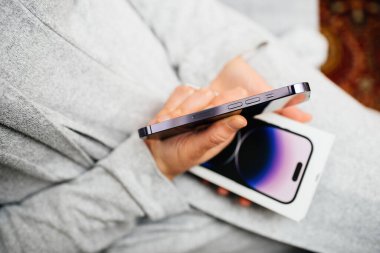 Londra, İngiltere - Bölüm 28, 2022: POV 'lu kadın, Apple Computers tarafından yeni piyasaya sürülen iPhone 14' ü gösteren paketi tutuyor - cerrahi kalitede paslanmaz çeliğe bakıyor