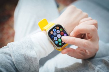 Londra, Birleşik Krallık - Bölüm 28, 2022: Yeni Apple Bilgisayarları 'nı tutan POV kadını Apple Watch Ultra giyilebilir, regl döngüsünü anlamak için uygulamanın döngüsüne bakıyor.