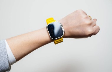Londra, Birleşik Krallık - Bölüm 28, 2022: POV 'lu kadın yeni Apple Compouters Watch Ultra' yı takarak el hareketi yapıyor - beyaz arka plan