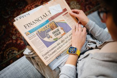 Londra, Birleşik Krallık - 28 Eylül 2022: üzerinde yeni Apple Watch ultra ile Financial Times okuyan ve İtalyan sonuç seçimleri yapan Apple Bilgisayarları satın almak - hepsi ekranda