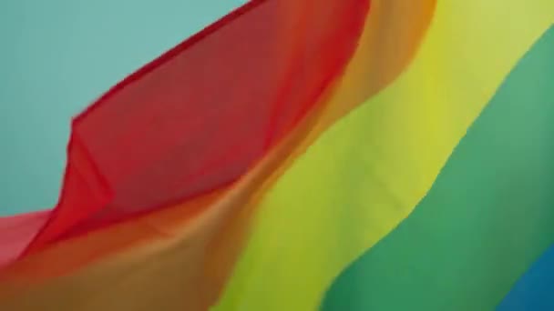 Lgbtqの旗は同性愛を表す ゲイの誇り虹のフラグを振って Lgbtqフラグ風の中で手を振る レズビアンの旗の背景 虹の旗4Kをループ リアル生地7色 ホモフォビアに対する国際デー — ストック動画