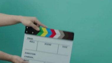 Alkış tahtası çarpıyor. Sinema filmi tabelası. Mavi ya da yeşil ekran renk arkaplanı üzerindeki boş film sayfasını kapatıyorum. Video prodüksiyonu için film tahtası kesme. film ya da film çekimi.