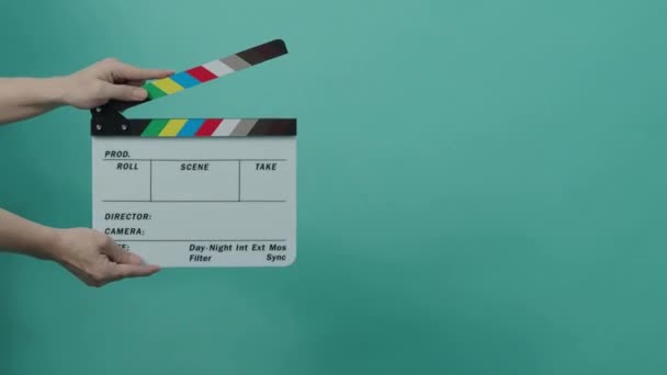 クラッパーボードがぶつかる 映画のスレート 手を閉じて青い画面や緑の画面の色の背景に空のフィルムスレートを拍手 ビデオ制作のためのフィルム スレート カッティングです 映画撮影 — ストック動画