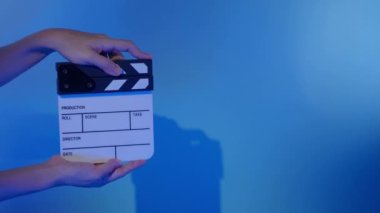 Film alçıpan görüntüsü. Adam film çekmeden ya da kaydetmeden önce el ele tutuşup stüdyoda alkışlıyor. Video kaydı için film alkış tahtası ya da film tahtası. Film yapımcılığı. film endüstrisi.