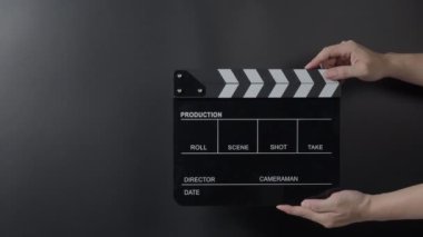 Film alçıpan görüntüsü. Adam film çekmeden ya da kaydetmeden önce el ele tutuşup stüdyoda alkışlıyor. Video kaydı için film alkış tahtası ya da film tahtası. Film yapımcılığı. film endüstrisi.