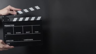 Film alçıpan görüntüsü. Adam film çekmeden ya da kaydetmeden önce el ele tutuşup stüdyoda alkışlıyor. Video kaydı için film alkış tahtası ya da film tahtası. Film yapımcılığı. film endüstrisi.