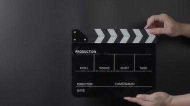 Film alçıpan görüntüsü. Adam film çekmeden ya da kaydetmeden önce el ele tutuşup stüdyoda alkışlıyor. Video kaydı için film alkış tahtası ya da film tahtası. Film yapımcılığı. film endüstrisi.