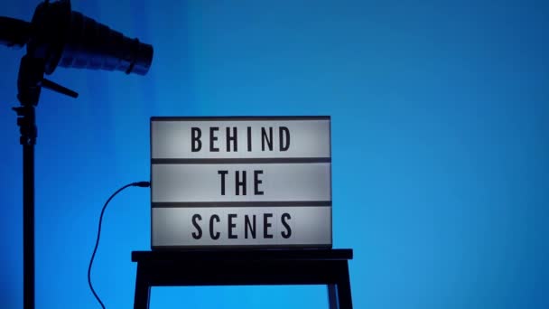 在电影院灯箱上的场景字母后面黑色文字在白色Led灯箱上的文字背后的场景 道具包括扩音器电影拍板和工作室的导演椅子 作录影用 — 图库视频影像