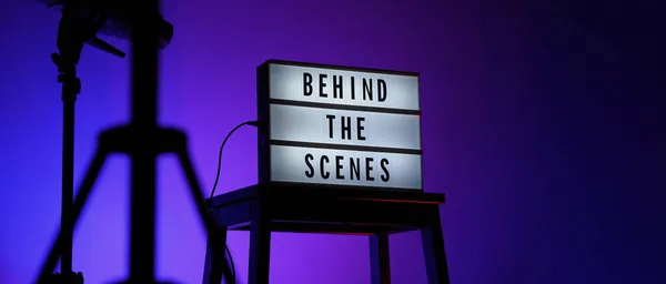 LightboxまたはCinema Lightボックスのシーンテキストの後ろにあります スタジオの階段と光の上の映画ボードライトボックスグラデーションの色の雪の三脚背景 舞台裏で活躍するチームが — ストック写真