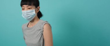 Aşı aşılama, hastalık önleme konsepti. Tıbbi maskeli kadın Covid 19 ya da grip aşısı yaptırıyor. Doktor enjeksiyondan önce ve sonra pamuk kullanıyor. Coronavirus aşılı kadın.