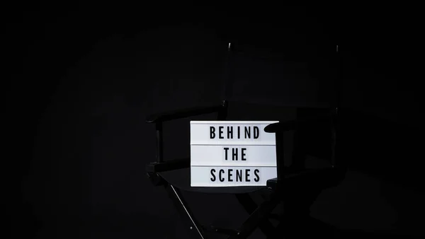 シーンバナーライトボックスの後ろに監督椅子 文字のテキストLightboxまたはCinema Lightボックス 映画のクラッパーボードと監督の椅子 黒の背景 シーンの裏側にあるビデオを表します — ストック写真