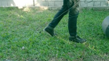 Elektrikli çim biçme makinesi. Çim biçme makineli bir adam. Statik çekim. Bahçe işleri. Bahçede elektrikli çim biçme makinesiyle çim biçmek. Çim biçme makinesi. Çimleri biçiyorum..