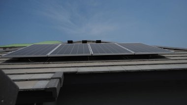 Fotovoltaik. Solarcell paneli. Bir yerleşim yerinin çatısında güneş enerjisi santrali. Çatıda voltaik paneller var. Fotovoltaik çatı. Güneş enerjisi konsepti. sürdürülebilir ve temiz güç.