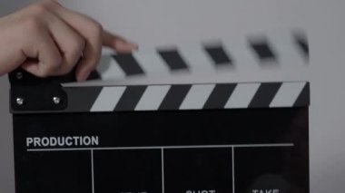 El çırpma tahtası. El ve film çekim tahtası arka plandaki stüdyoda izole edilmiş. Film ya da video yapım konsepti. Alkışlayıcılar kapanıyor. Film ekibi video kaydı için elinde film tahtası tutuyor.