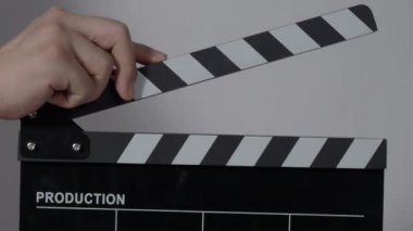 El çırpma tahtası. El ve film çekim tahtası arka plandaki stüdyoda izole edilmiş. Film ya da video yapım konsepti. Alkışlayıcılar kapanıyor. Film ekibi video kaydı için elinde film tahtası tutuyor.