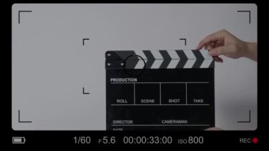 El çırpma tahtası. El ve film çekim tahtası arka plandaki stüdyoda izole edilmiş. Film ya da video yapım konsepti. Alkışlayıcılar kapanıyor. Film ekibi video kaydı için elinde film tahtası tutuyor.