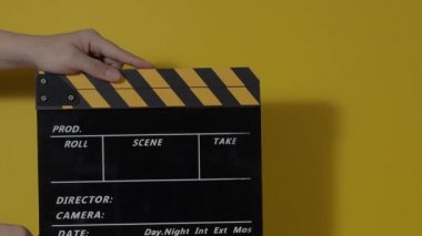 El çırpma tahtası. El ve film çekim tahtası arka plandaki stüdyoda izole edilmiş. Film ya da video yapım konsepti. Alkışlayıcılar kapanıyor. Film ekibi video kaydı için elinde film tahtası tutuyor.