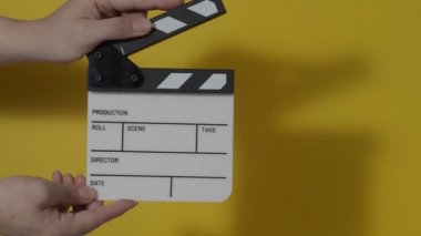 El çırpma tahtası. El ve film çekim tahtası arka plandaki stüdyoda izole edilmiş. Film ya da video yapım konsepti. Alkışlayıcılar kapanıyor. Film ekibi video kaydı için elinde film tahtası tutuyor.